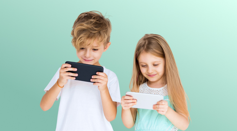 2 ребенка стоят со смартфонами и смотрят в них, какой же лучше выбрать для ребенка телефон